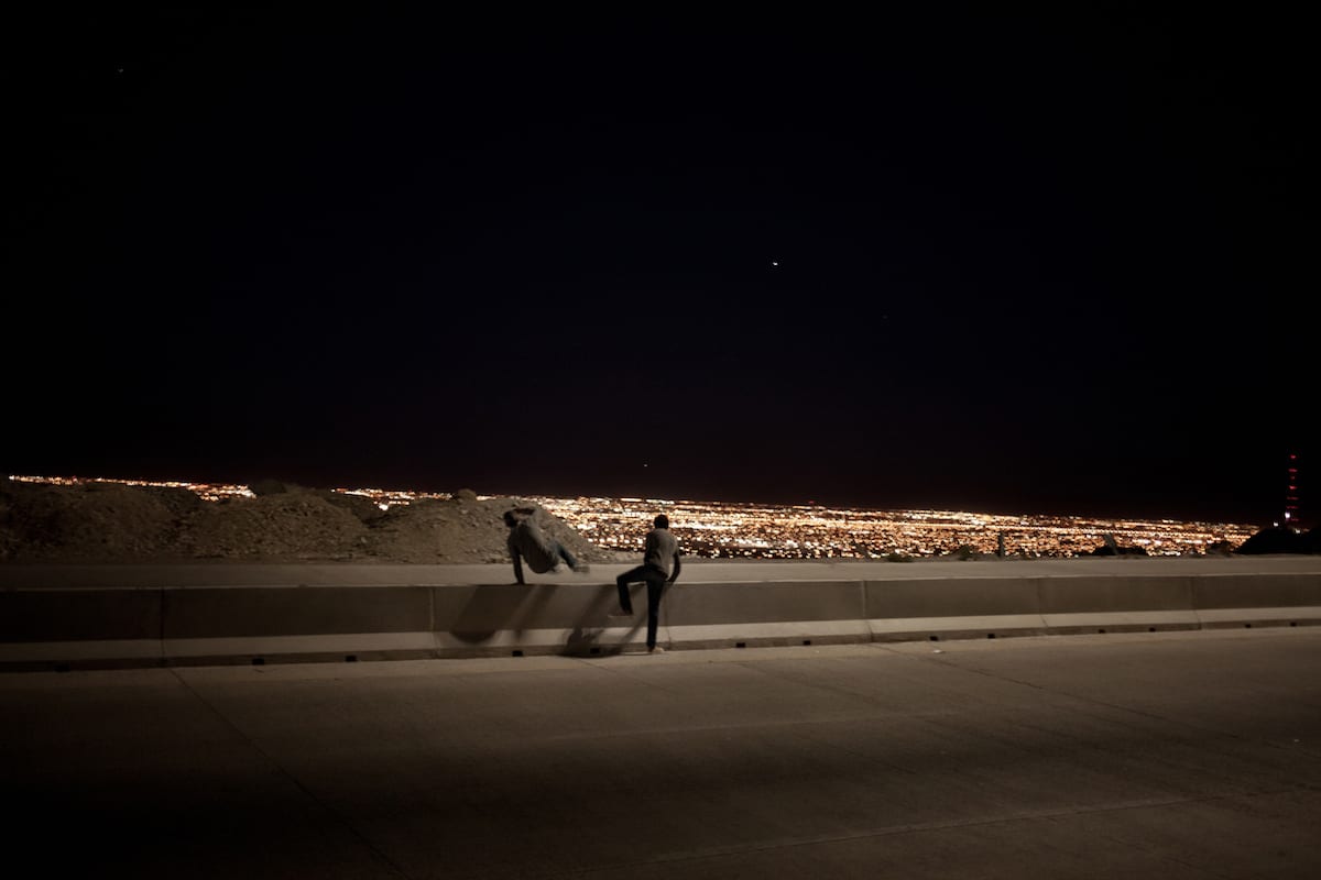 Manny and Alejandro jump across the newly lit section Camino Real which overlooks the city on their way back to their neighborhood. The highway has been a popular place to dump bodies in the past decade.