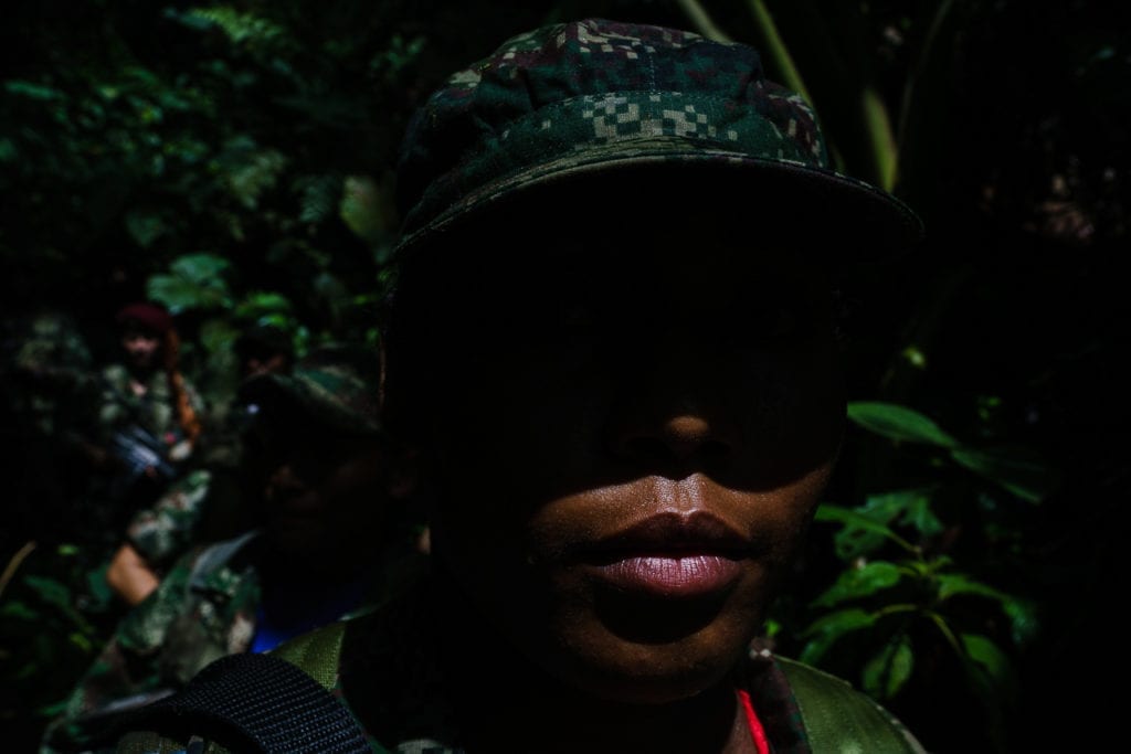 Alejandra walks with her team for long hours in the sun. The guerrillas change their positions frequently for security reasons -- 40% of them are female. 3 May 2016. Photo © Federico Rios.