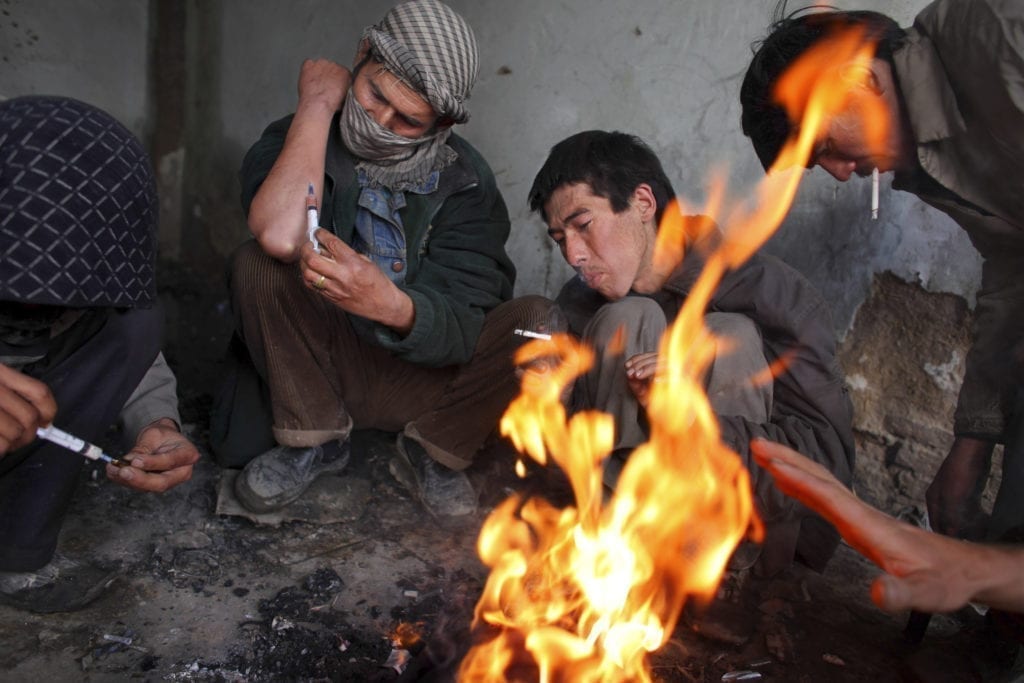 Heroin addicts inject while trying to keep warm inside the abandoned Russian Cultural center, used as a common gathering point for the drug users in the capitol city. Heroin is readily available, costing about one dollar a hit. February 09, 2009