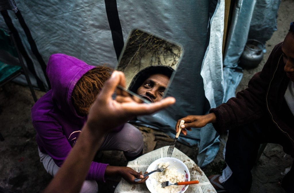 Programme Name: Exodus: Our Journey to Europe - TX: n/a - Episode: n/a (No. 3) - Picture Shows: refugees sharing a meal in the Calais Jungle. - (C) Gus Palmer / KEO Films - Photographer: Gus Palmer