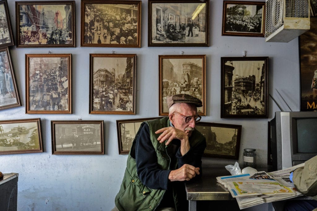 Disappearing Home-London East End's English community. 15. Mr Broomfield, fishmonger and former photographer, surrounded by his photographs of the London old Billingsgate Fish Market at the George's Plaice, Roman Road, Bow on the 11th March 2015, London.