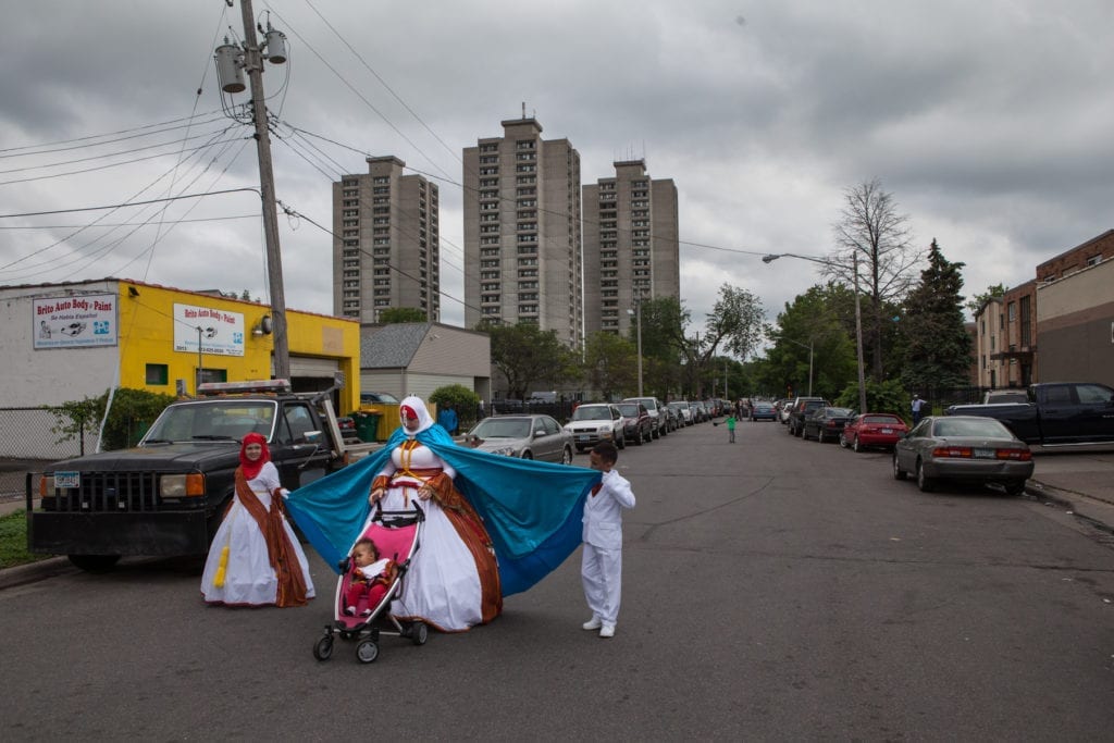 Two children help a woman with her costume, designed with the colours of the Somali flag, in preparation for the annual Somali Independence Day Parade in 2015. The event, which drew hundreds of people, was hosted by Ka Joog, a Somali-run non-profit that focuses on youth outreach programmes, especially within the Somali community © Arthur Nazaryan 