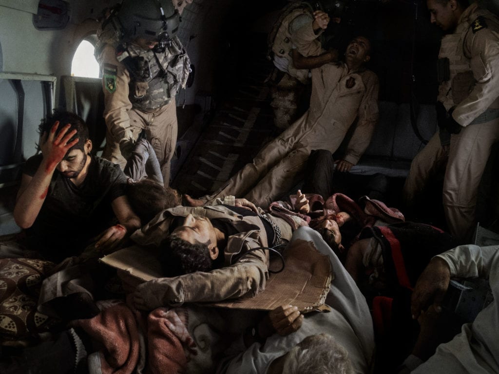 IRAQ. Sinjar Mountains. 2014. Injured survivors of an Iraqi Air Force helicopter crash in Mount Sinjar lie onboard a rescue helicopter on its way to Iraqi Kurdistan. The survivors included Yazidi civilians, Kurdish and Iraqi Army personnel, and journalists. The Yazidis were fleeing persecution at the hands of Islamist extremists who had recently taken over their hometowns in Iraq's Ninevah province. In the high grounds of Mount Sinjar, thousands of Yazidis found safety from ISIS, but also the risk of dying from hunger and thirst. The first rescue helicopter had been sent to save the besieged civilians from that dismal fate, but it crashed into the side of the mountain shortly after takeoff.