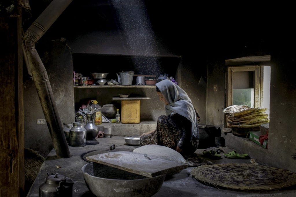 Afghanistan. 2011. An Afghan woman bakes bread in the border town of Badakhshan.