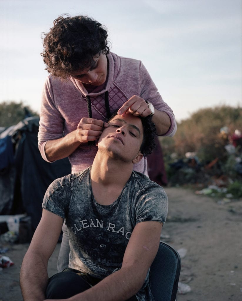 North African men threading their eyebrows. Calais, France, November 2015. From the series Foreigner: Migration into Europe 2015-2016 © Daniel Castro Garcia