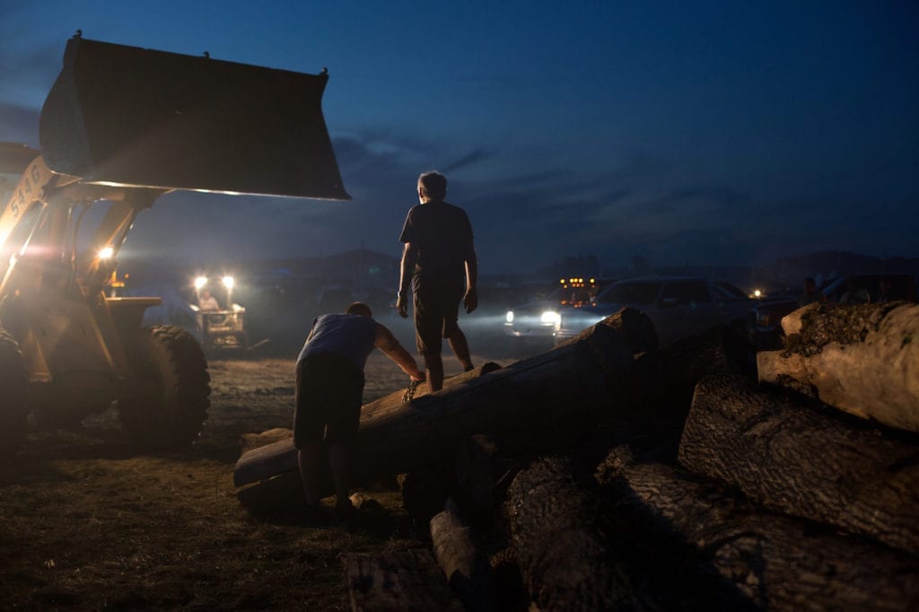 Work is life - In camp, every day tasks like cooking and chopping wood are the front line. Here men unload a massive donation of firewood.