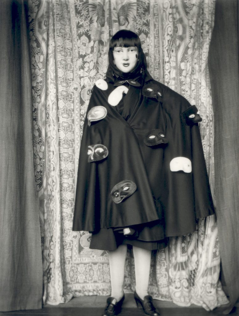 Self-portrait (full length masked figure in cloak with masks) by Claude Cahun, 1928 © Jersey Heritage