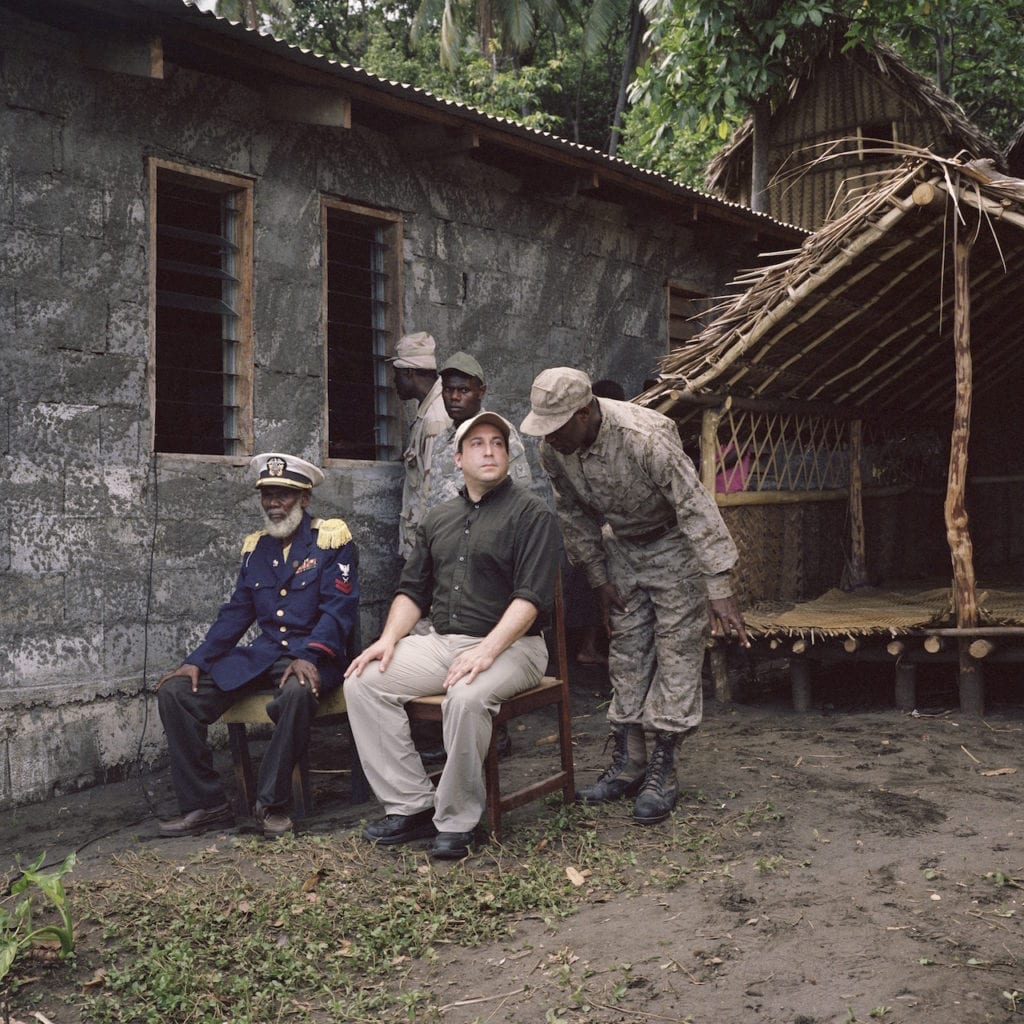 Chief Isaak of the John Frum Movement, at their village in Sulphur Bay on Tanna, sits overlooking the celebrations with Cevin during John Frum Day, February 2014. From the series Cargo © Jon Tonks