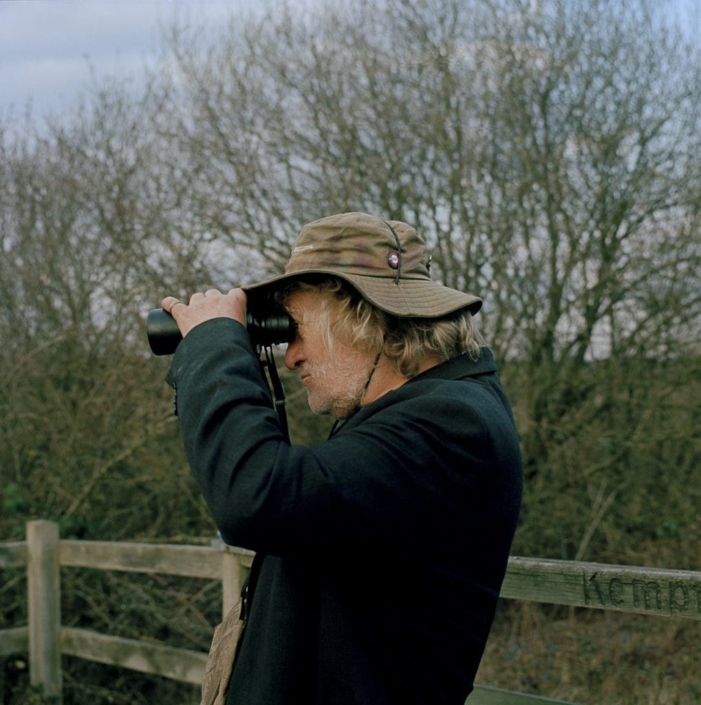 I remember when I was aged ten or so the local lads would take the mickey out of me because Justin, in his late teens at the time, would walk bare-footed around Briston in Norfolk, where I went to the village school. By this time, Justin had firmly embraced the ‘hobo-hippy’ lifestyle, but it was always the bird watching that really mattered. Today it’s this passion that brings the light to the shade; when Justin does remark on having a good day, there is normally a list of birds to follow. From the series Big Brother © Louis Quail