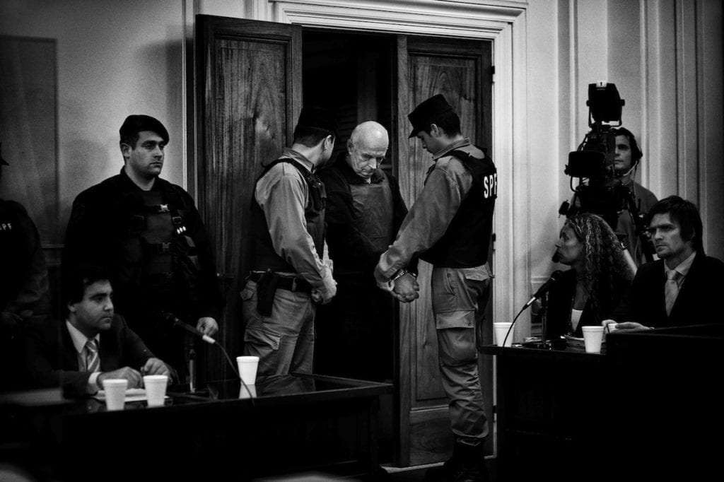 Von Wernich, wearing a bullet-proof vest, enters the courtroom before the verdict. The court found him guilty of complicity in seven homicides, 42 kidnappings, and 32 instances of torture and sentenced him to life imprisonment. La Plata, Buenos Aires Province, Argentina, 2007 © Giancarlo Ceraudo, courtesy of the artist