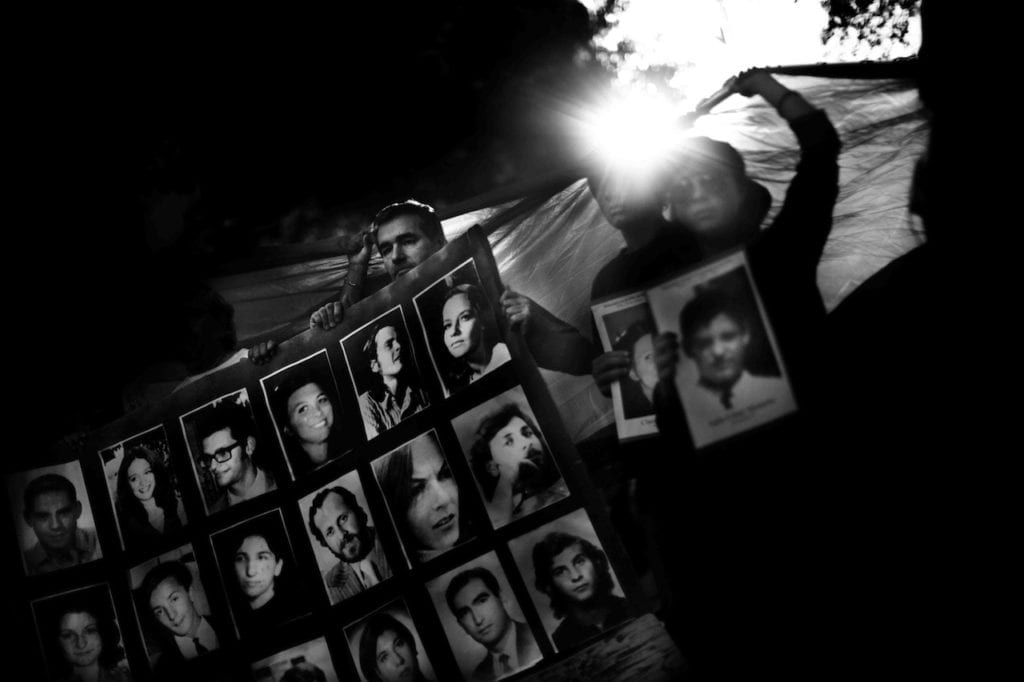 People holding some photographs of desaparecidos at a public rally during the anniversary of the 1976 military coup. Buenos Aires, Argentina, 24 March 2011 © Giancarlo Ceraudo, courtesy of the artist