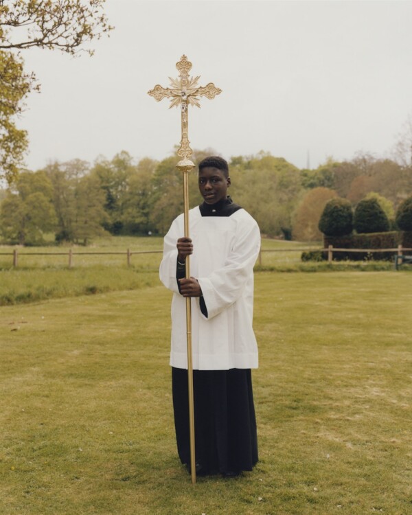 Acolyte holding the golden cross.